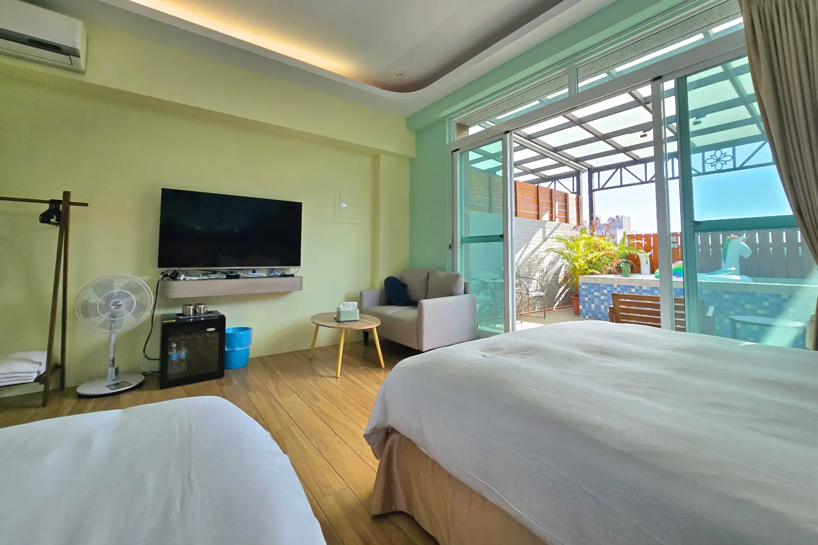 201小海龜四人房，電視、沙發座位與陽台戲水池