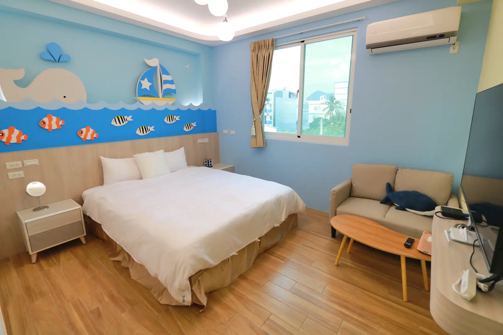 302小鯨魚雙人房，床鋪、茶几與電視
